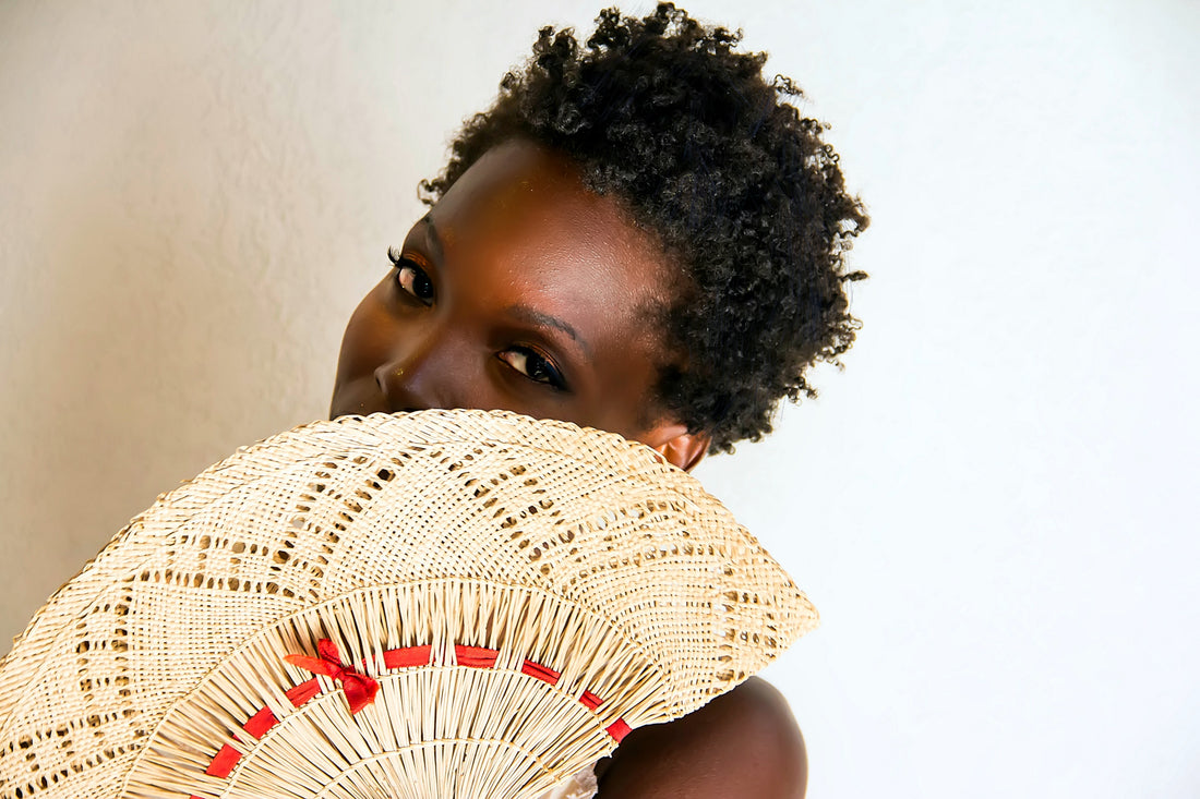 black woman, fan in front of face