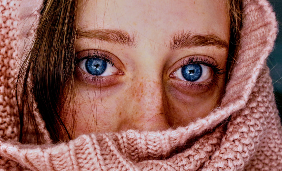 woman peaking through knit scarf