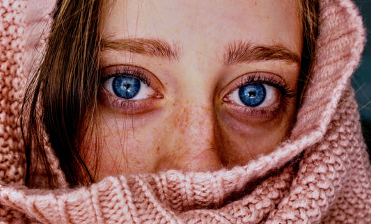 woman peaking through knit scarf